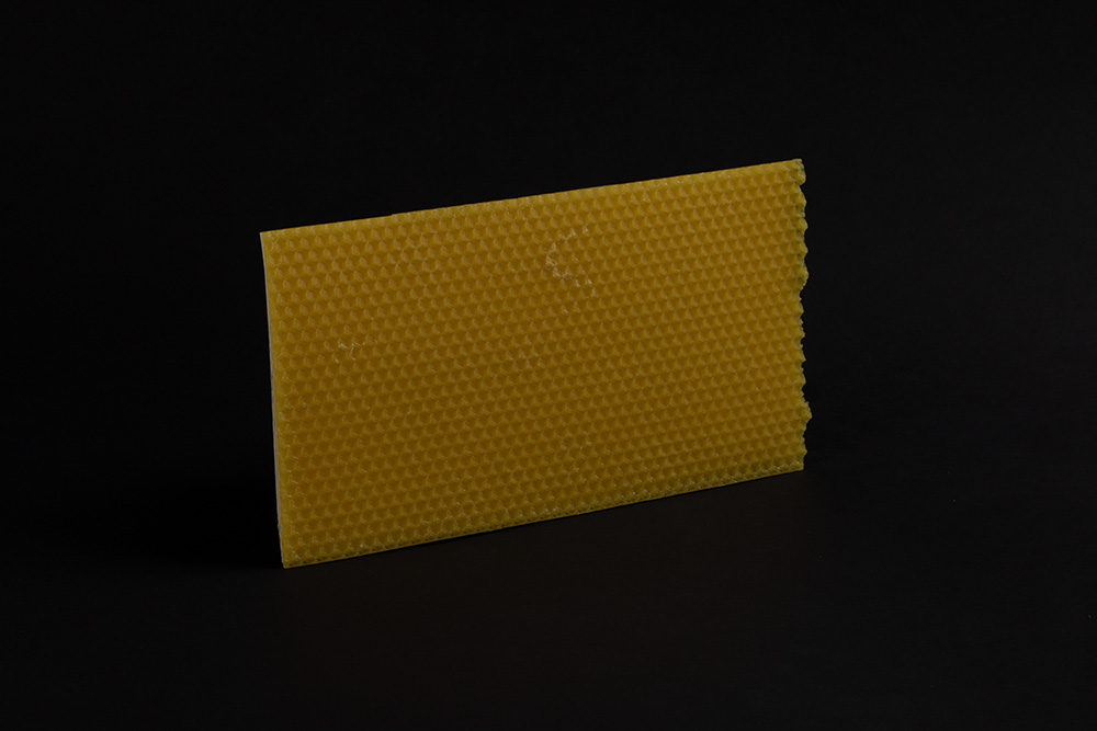 Zu sehen ist gelber Bienenwachs in einer quadratischen Form. 