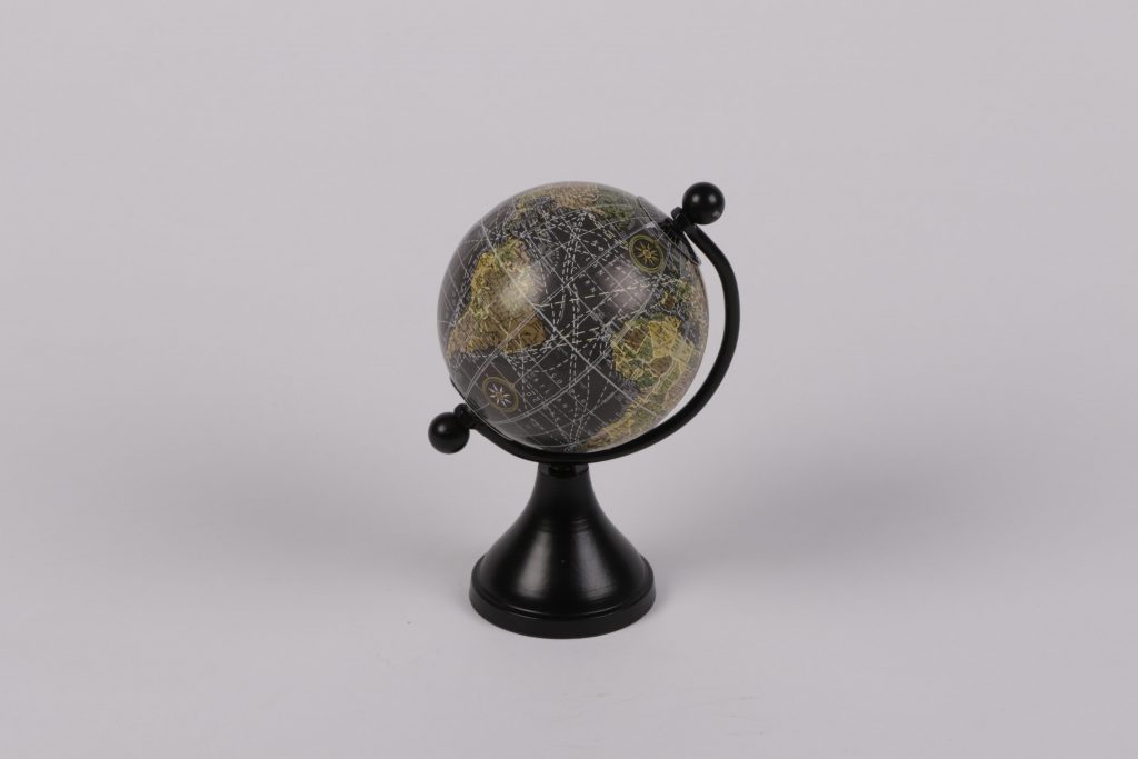 Auf dem Bild ist ein circa 10cm hoher Globus abgebildet. Die Erdkugel besteht aus den Farben Dunkelblau, für das Wasser und Grün, für die Landschaft. Das Gestell ist Schwarz und aus Metall.