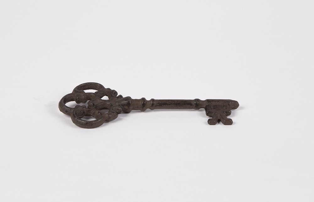 Zu sehen ist ein Metallener, alter, verzierter Schlüssel.