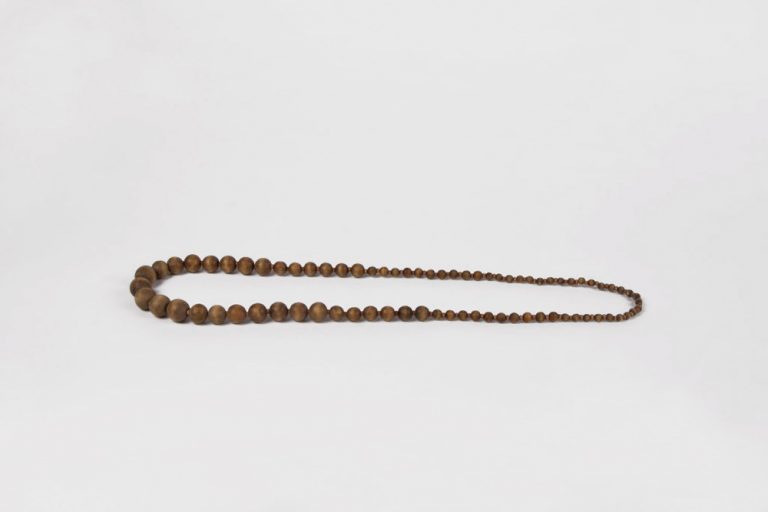 Zu sehen ist eine liegende Perlenkette aus Holzperlen.
