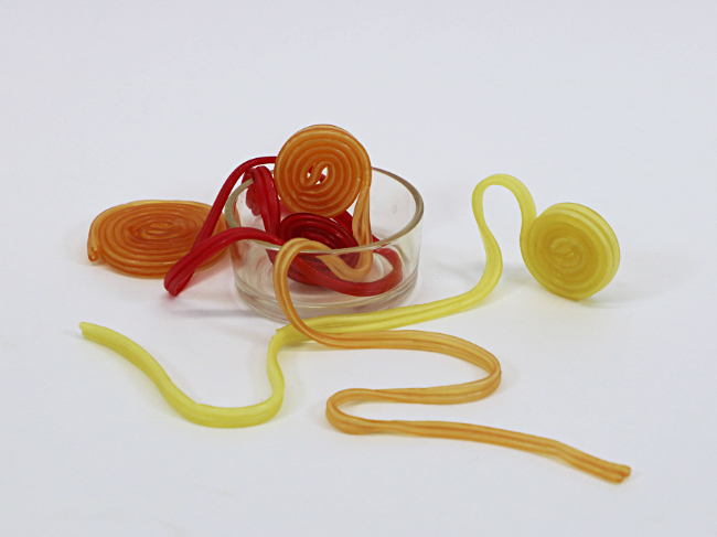 4 verschiedene Gummischlangen: gelb, orange, rot
teils aufgewicket, teils ausgerollt
in einem kleinen Glas