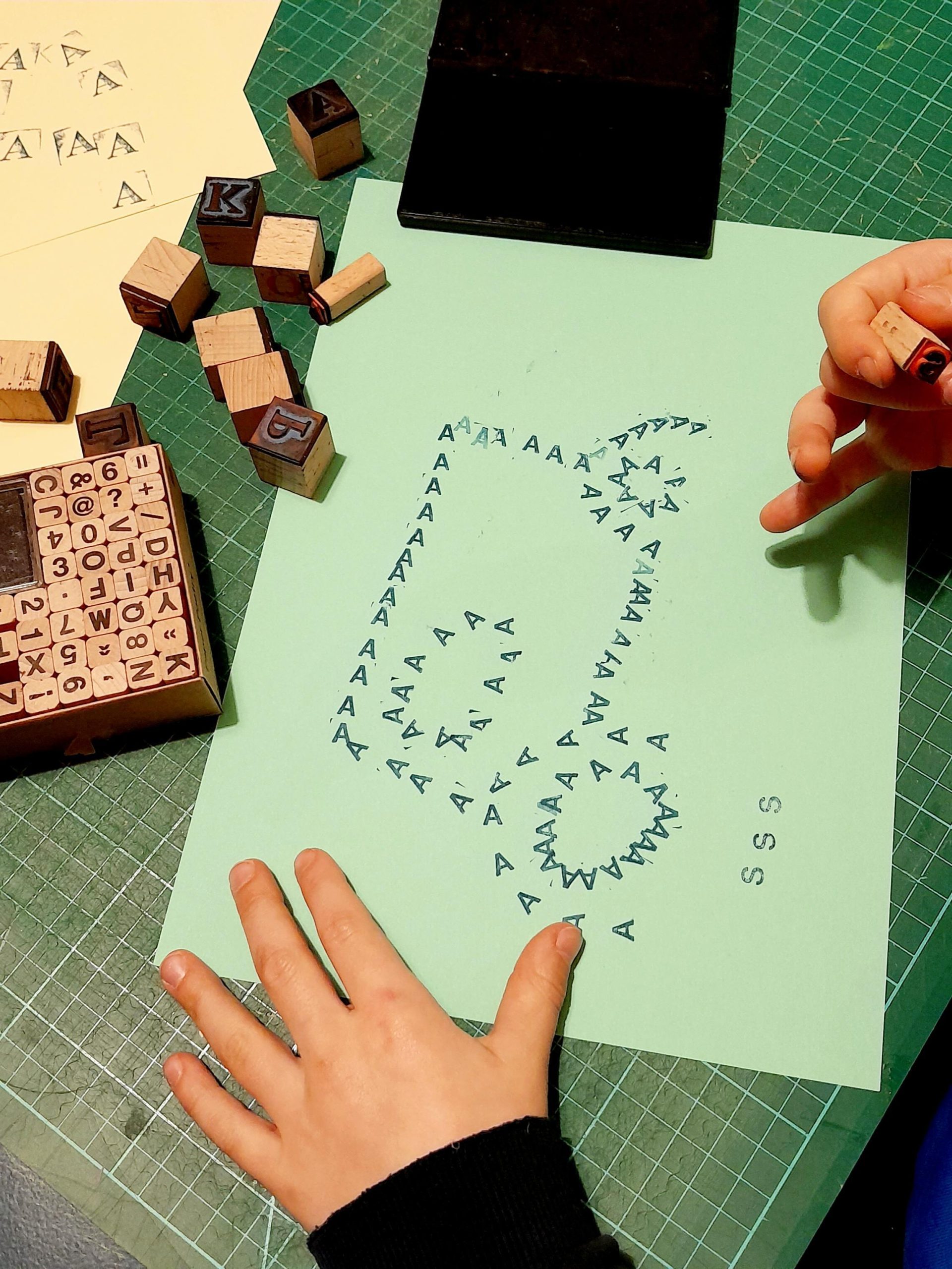 Kind stempelt mit Buchstaben A