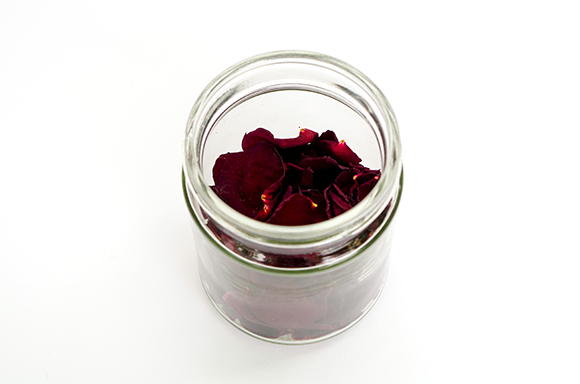 Getrocknete Rosenblüten in einem durchsichtigen Glas.