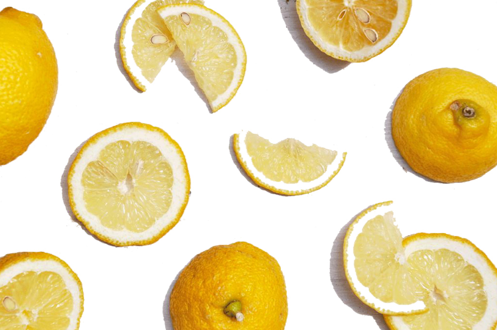 Halbierte Zitronen und Zitronenscheiben auf weißem Grund
